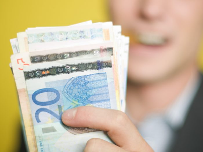 Man smoking cigar and holding money