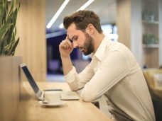 man-with-hand-on-temple-looking-at-laptop-842554