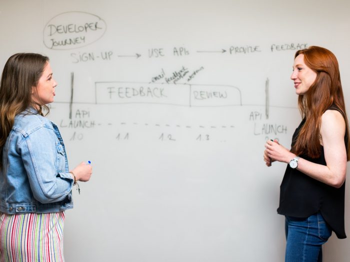 women-standing-beside-whiteboard-3861952