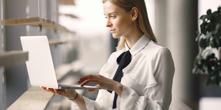 focused-worker-using-laptop-in-office-lobby-4173263